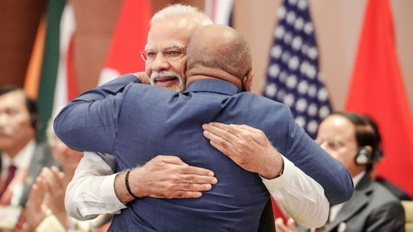 Indien, Neu Delhi: Narendra Modi (l), Premierminister von Indien, umarmt beim G20-Gipfel bei der ersten Arbeitssitzung Azali Assoumani von der Afrikanischen Union (AU).