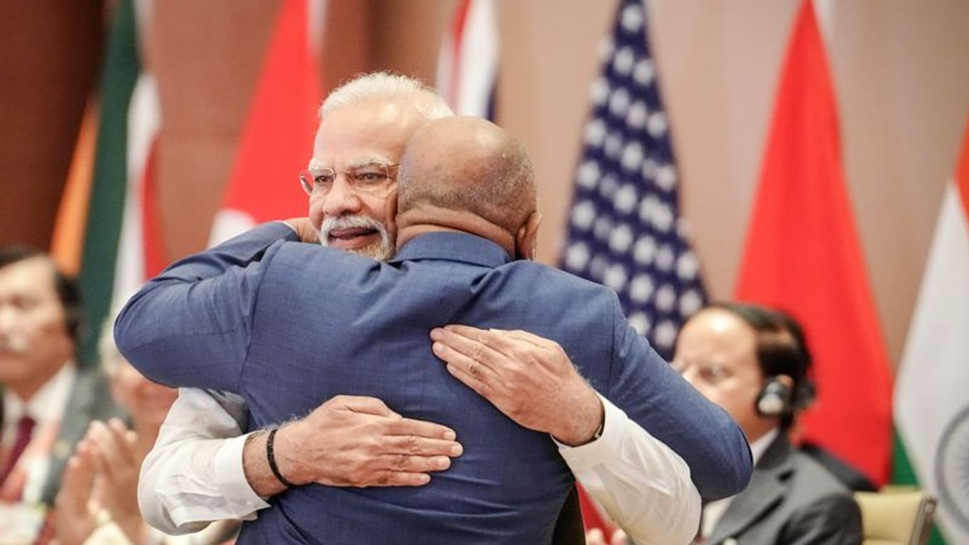 Indien, Neu Delhi: Narendra Modi (l), Premierminister von Indien, umarmt beim G20-Gipfel bei der ersten Arbeitssitzung Azali Assoumani von der Afrikanischen Union (AU).