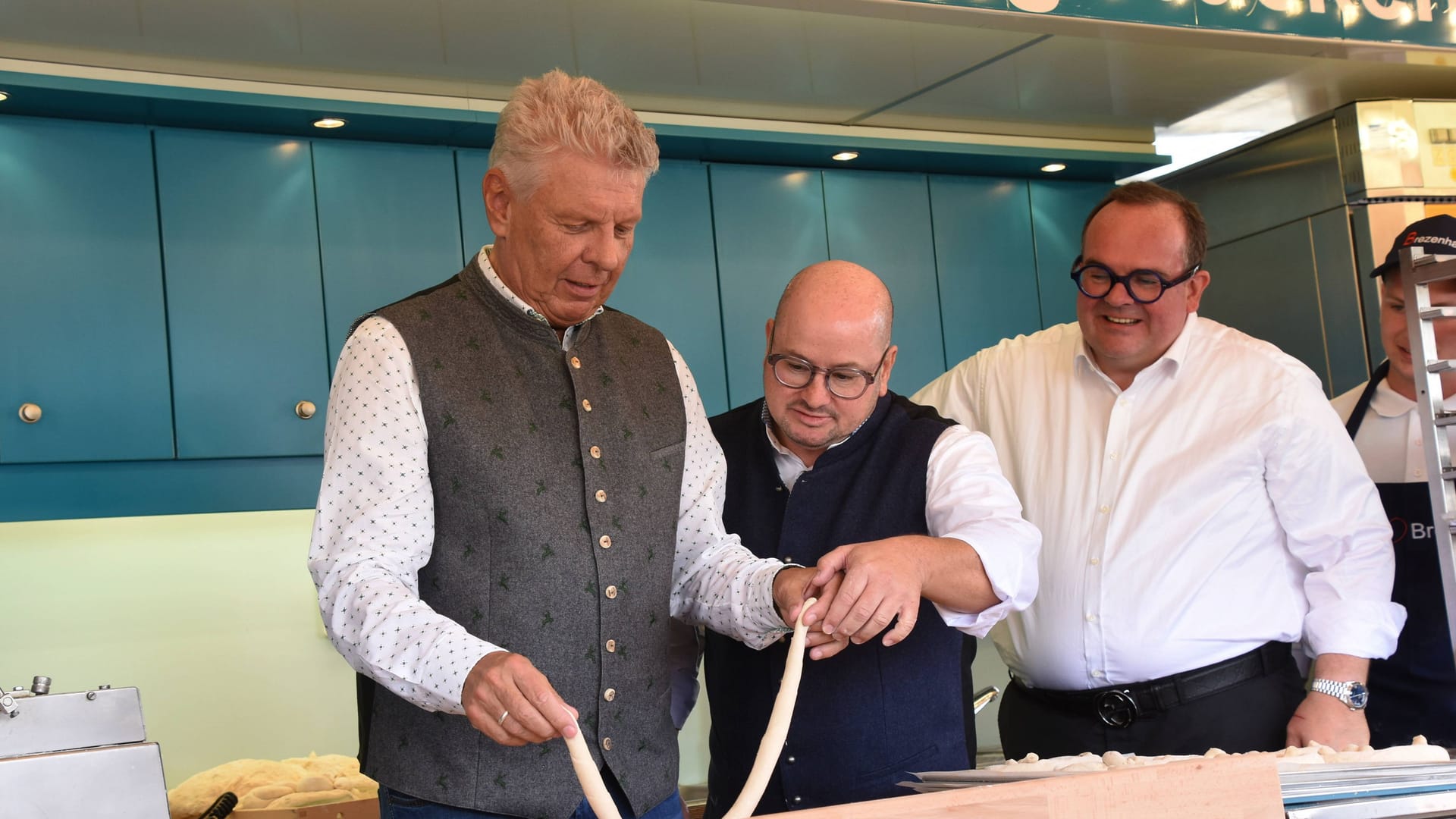 Münchens Oberbürgermeister Dieter Reiter (von links), Standchef Karl-Heinz Hartnagel und Wiesn-Chef Clemens Baumgärtner am Brezenstand.