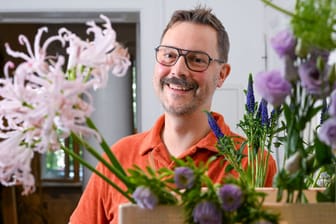 Berlin: Der Florist Nicolaus Peters steht hinter Blumen, aus denen er einen Blumenstrauß bindet. Der Berliner hat die Floristik-Weltmeisterschaft in England gewonnen.