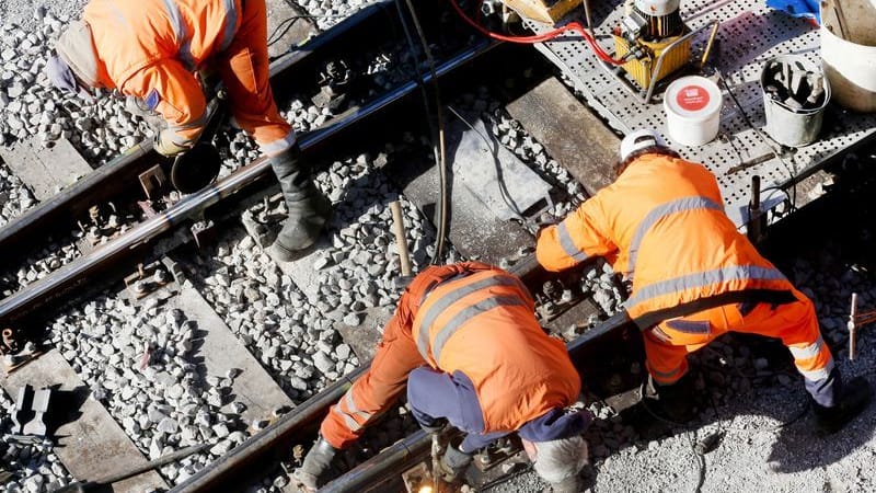 Ein Bautrupp der Bahn repariert auf einer Strecke ein Gleisbett für Züge