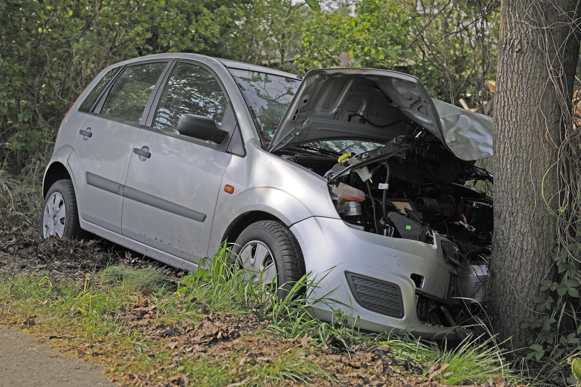 Ein demoliertes Auto (Symbolbild): In Köln ist ein Pkw von der Fahrbahn abgekommen und mit einem Baum kollidiert.