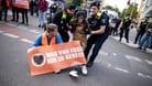 Polizisten räumen Teilnehmer einer Demonstration der Klimaschutzgruppe Letzte Generation auf der Potsdamer Straße, die die Straße blockieren.