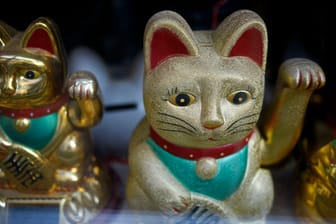 Goldene Maneki-neko: Die Pfotenbewegungen sollen keine freundliche Begrüßung sein.