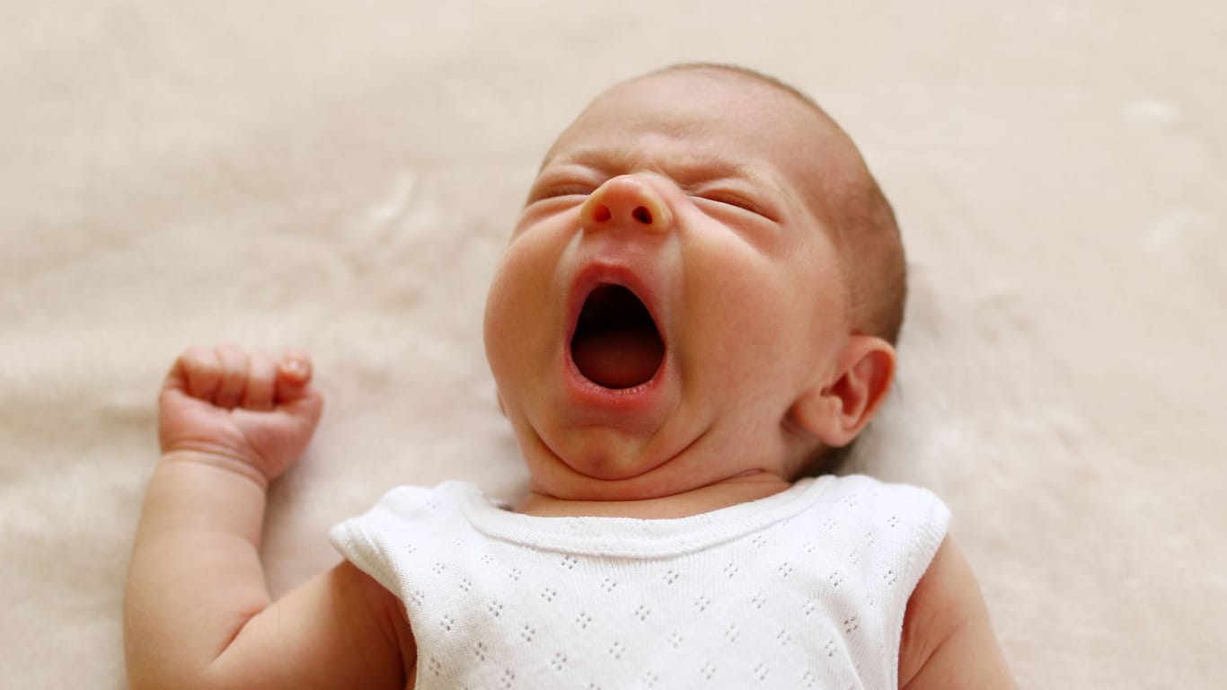 Baby gähnt: Für einen erholsamen Schlaf sorgt auch der richtige Schlafsack.