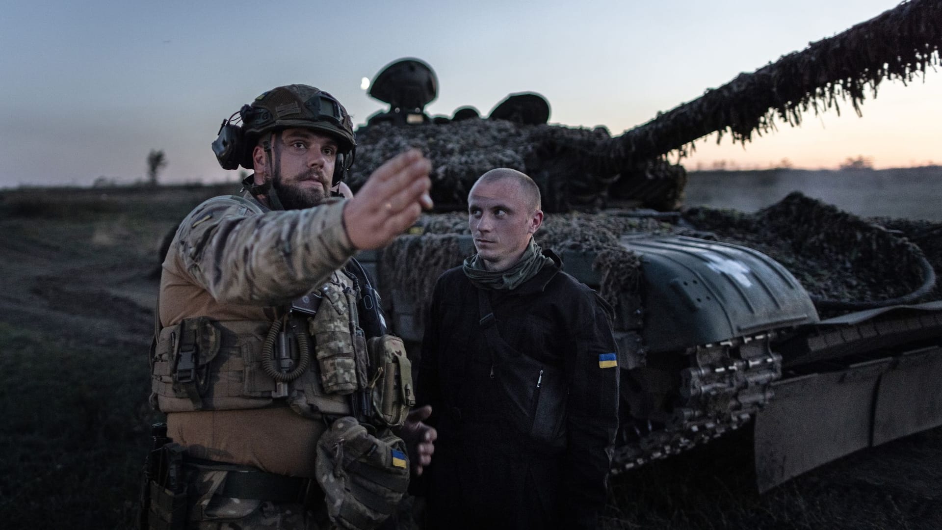 Ein kommandierender Soldat der 22. Brigade der Ukraine gibt bei einer Nachtschießübung vor einem T-72 Panzer Anweisungen.