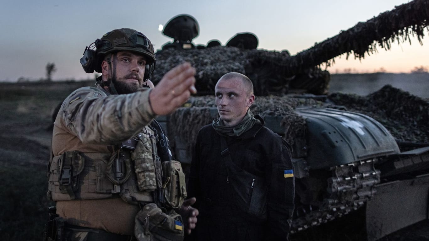 Ein kommandierender Soldat der 22. Brigade der Ukraine gibt bei einer Nachtschießübung vor einem T-72 Panzer Anweisungen.