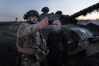 Ein kommandierender Soldat der 22. Brigade der Ukraine gibt bei einer Nachtschießübung vor einem T-72 Panzer Anweisungen.