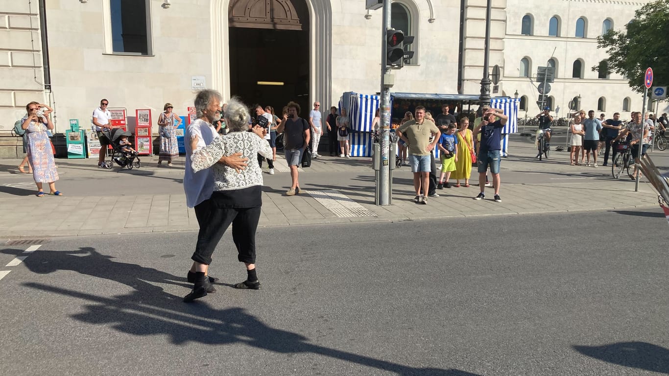 Mitglieder der Band tanzen während der Blockade am Geschwister-Scholl-Platz auf der Straße.