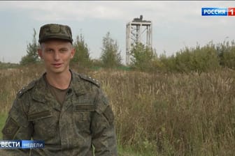 Russischer Soldat im Staatssender "Rossija 1": Auf dem markanten Turm im Hintergrund hat die Armee ein Flugabwehrgeschütz vom Typ Pantsir S-1 aufgestellt.