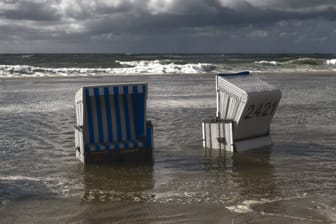 Strandkörbe während einer Sturmflut auf Sylt (Archivbild): Eine KI zeichnet ein düsteres, aber hoffnungsvolles Bild von der Zukunft der Urlaubsinsel.