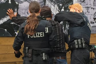 Polizisten kontrollieren einen Mann im Frankfurter Bahnhofsviertel auf illegalen Drogen- oder Medikamentenbesitz.