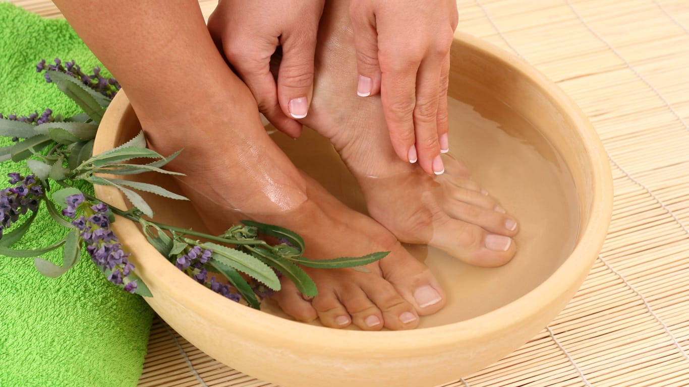Ein Fußbad mit Natron und ätherischen Ölen kann gegen Hornhaut helfen.