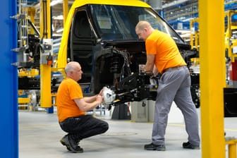 Arbeiter bauen ein elektrisches Auto zusammen (Symbolfoto): Die Autohersteller klagen über Auftragsmangel.