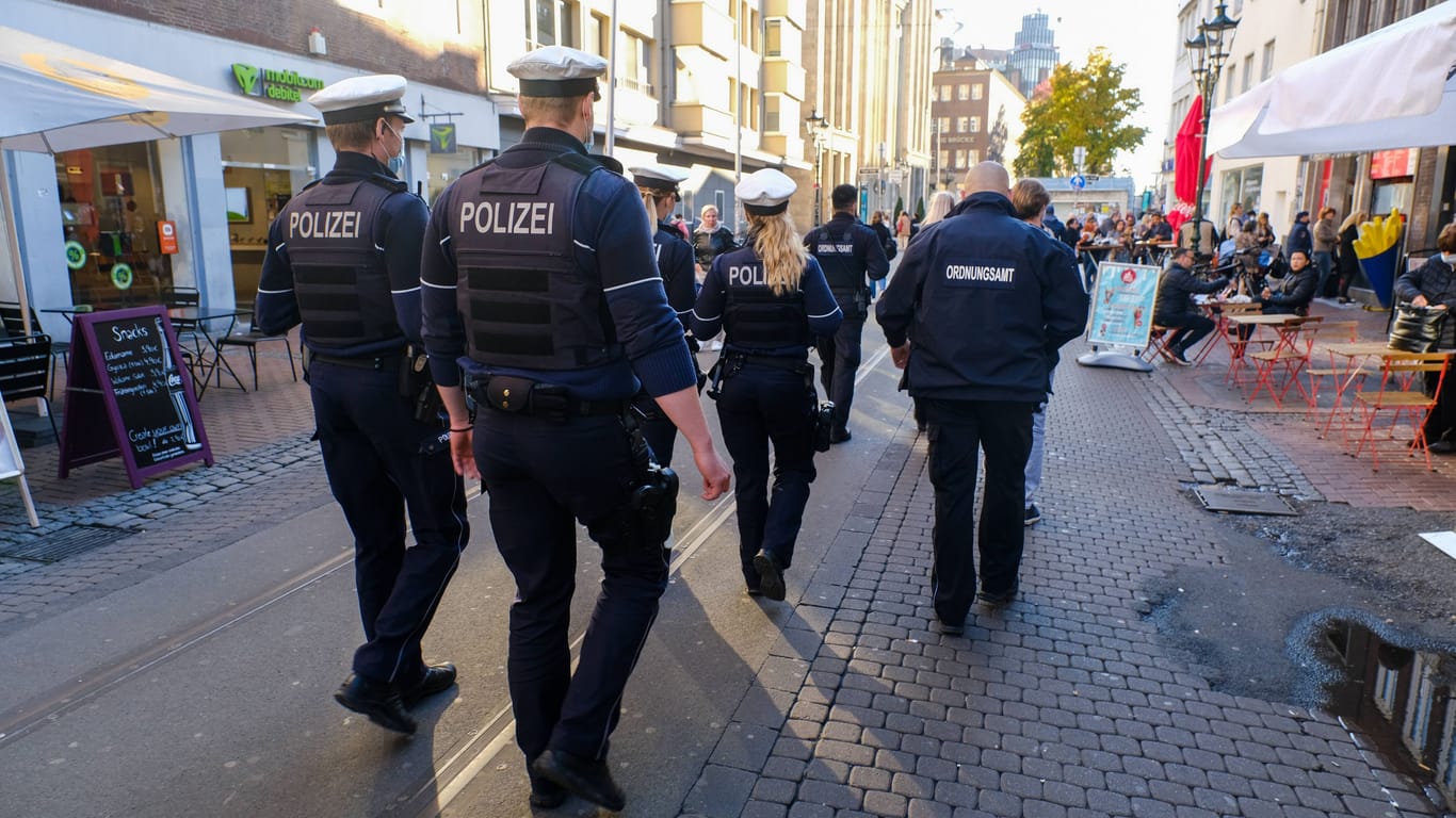 Polizeibeamte laufen durch die Altstadt in Düsseldorf (Symbolbild): Hier wurde im Januar ein Mann so schwer getreten, dass er starb.