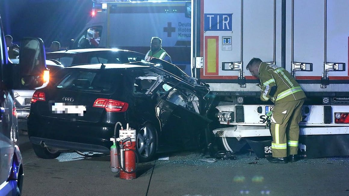 Rettungsdienstmitarbeiter schauen sich das Unfallauto auf der A4 an: Mehrere Menschen wurden bei dem Unfall verletzt.