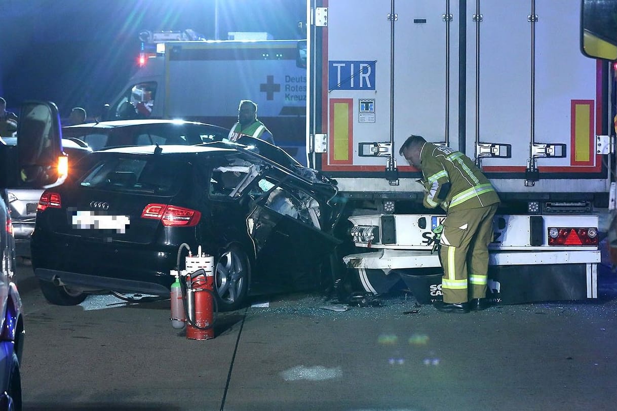 Rettungsdienstmitarbeiter schauen sich das Unfallauto auf der A4 an: Mehrere Menschen wurden bei dem Unfall verletzt.