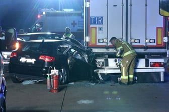 Rettungsdienstmitarbeiter schauen sich das Unfallauto auf der A4 an: Mehrere Menschen wurden bei dem Unfall verletzt.