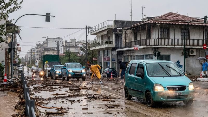 Ein Mann säubert die Straße nach dem Hochwasser in Volos.