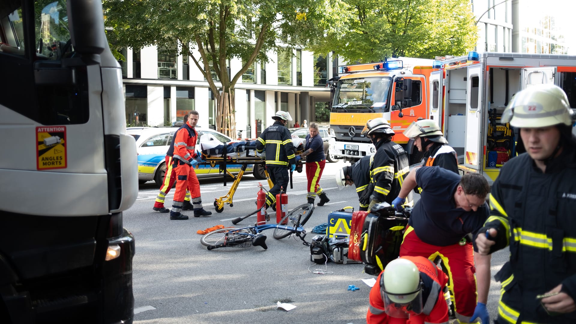 Einsatzkräfte an der Unfallstelle versorgen die Frau: Ihr Fahrrad liegt noch auf der Straße. Einsatzkräfte an der Unfallstelle versorgen die Frau: Ihr Fahrrad liegt noch auf der Straße.