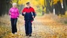 Mann und Frau höheren Alters beim Nordic Walking