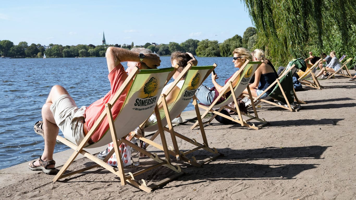 Menschen genießen das Wetter an der Hamburger Außenalster: Am Wochenende bleibt es heiß in der Hansestadt und in Schleswig-Holstein.