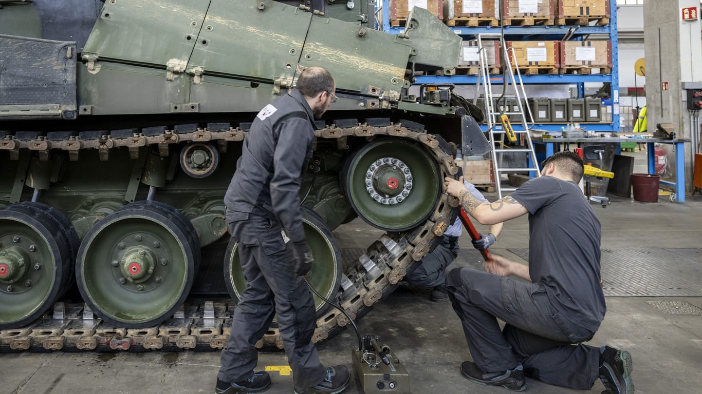 Mechaniker warten einen Leopard 2 in einer Wartungshalle des Schweizer Rüstungskonzern RUAG in Thun.