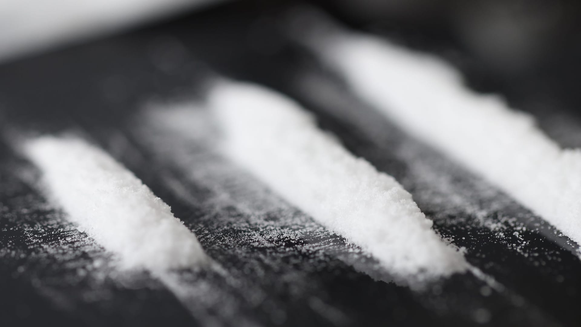 Closeup of white narcotic powder tracks on black background