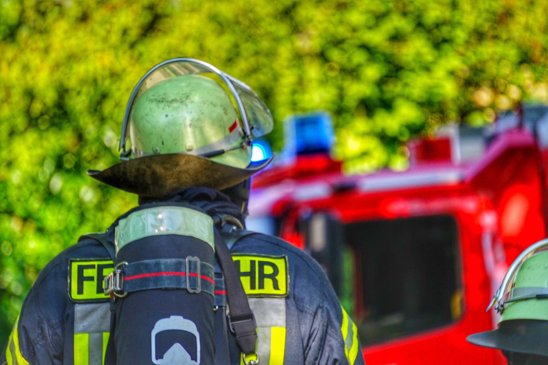 Ein Feuerwehrmann steht vor einem Einsatzfahrzeug (Symbolbild): Der Brand ist seit dem Morgen gelöscht.