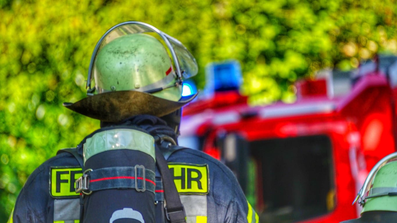 Ein Feuerwehrmann steht vor einem Einsatzfahrzeug (Symbolbild): Der Brand ist seit dem Morgen gelöscht.