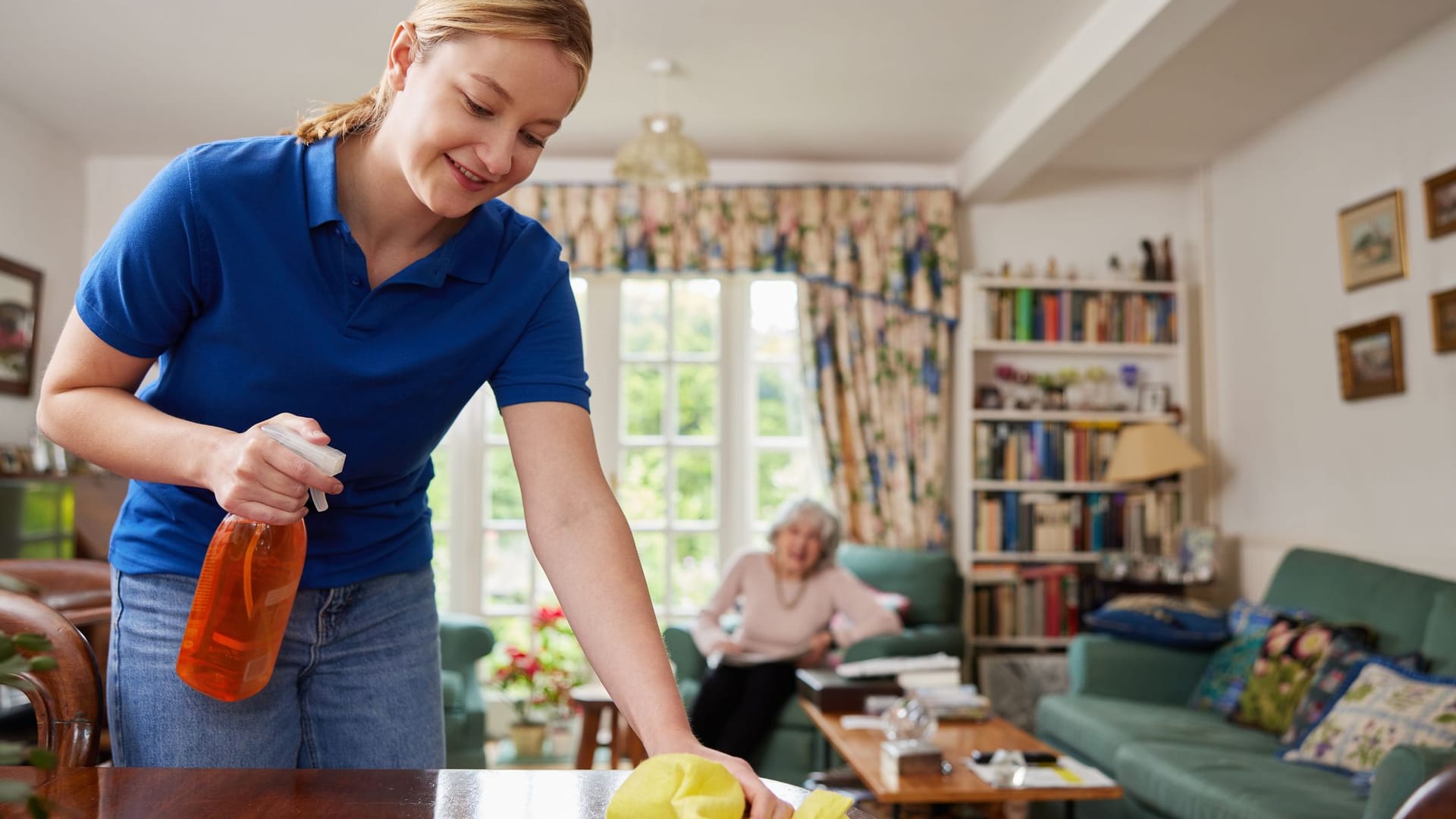 Weibliche Haus Hilfe Reinigung Haus und im Gespräch mit Seniorin