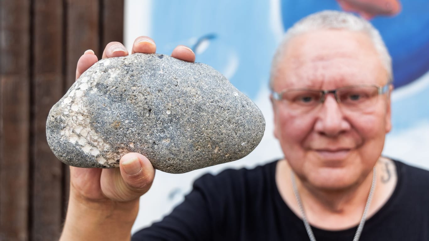 Hobby-Forscher Thomas Freiberg zeigt den Stein, in dem links die Versteinerung eines Seesterns zu erkennen ist.
