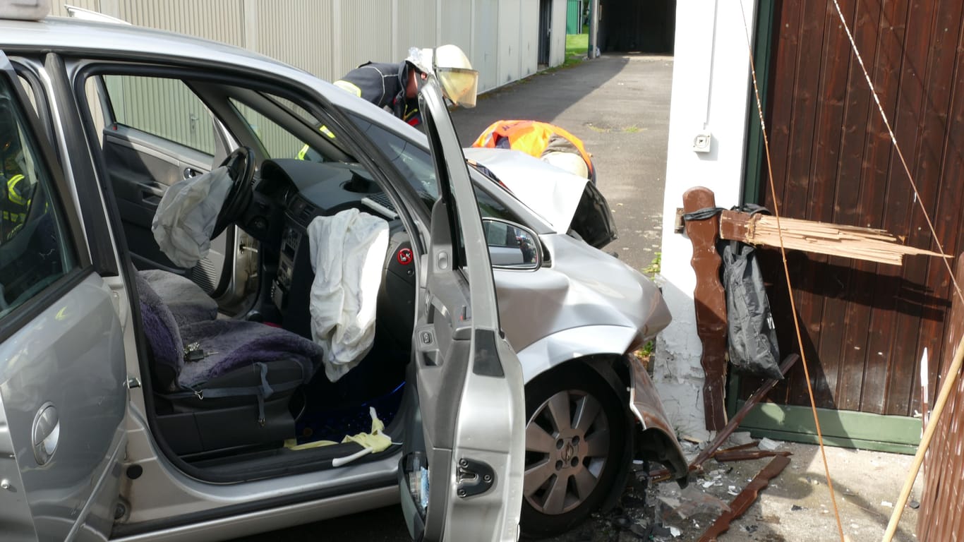 Der Unfallwagen: Einsatzkräfte der Feuerwehr begutachten den Schaden.
