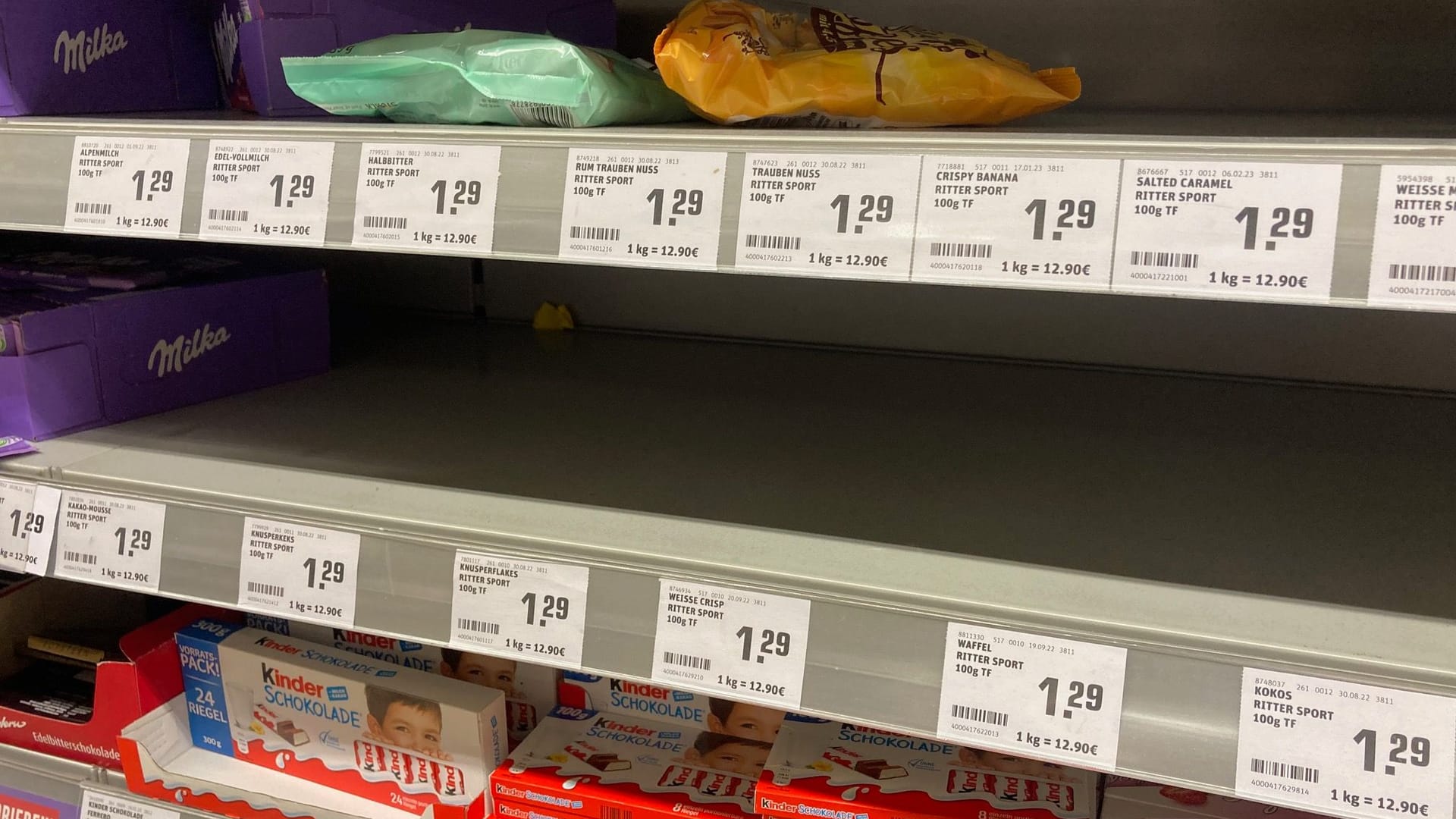 Leere Süßwarenregale bei Rewe.