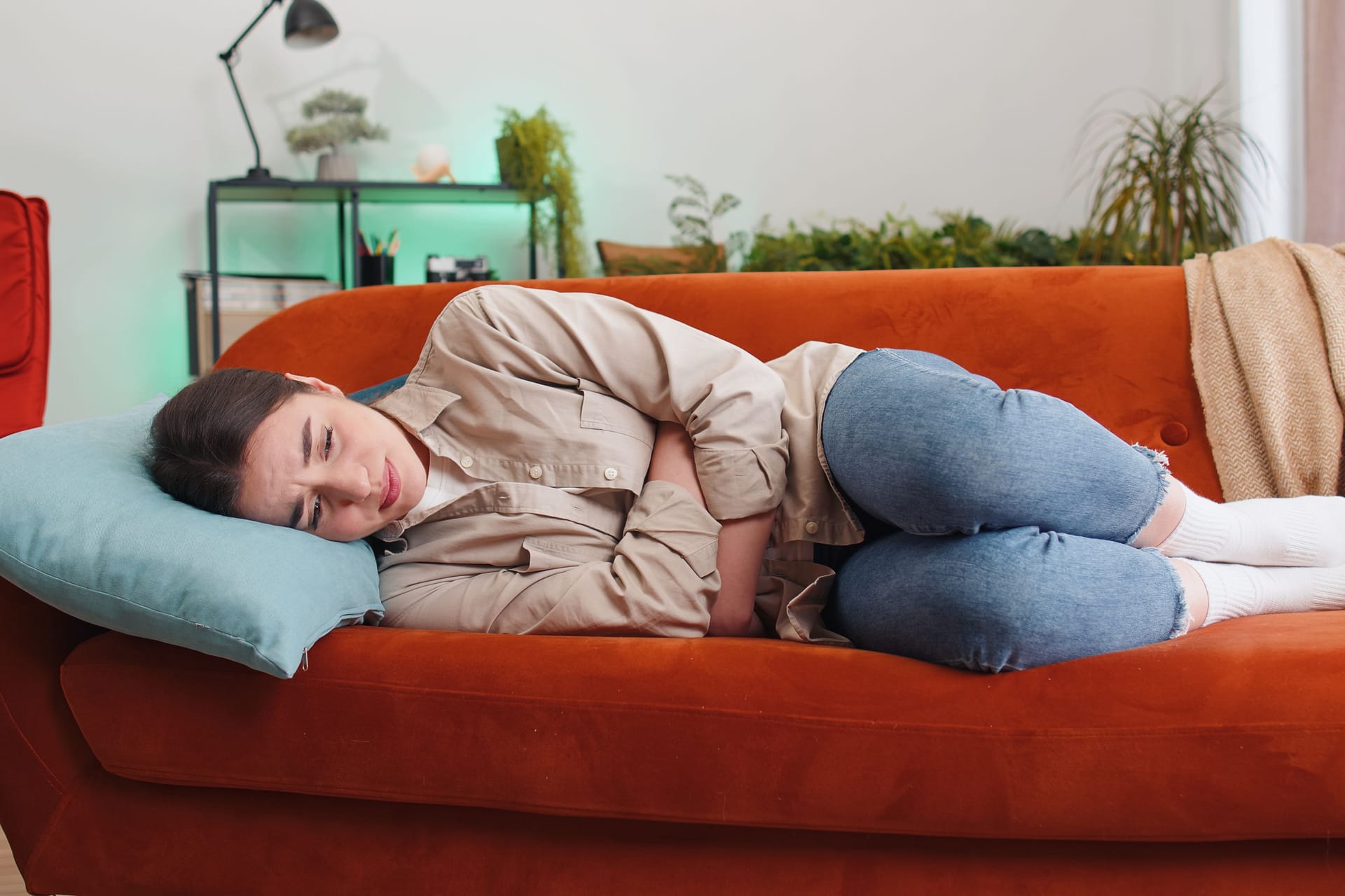 Eine Frau liegt auf dem Sofa.