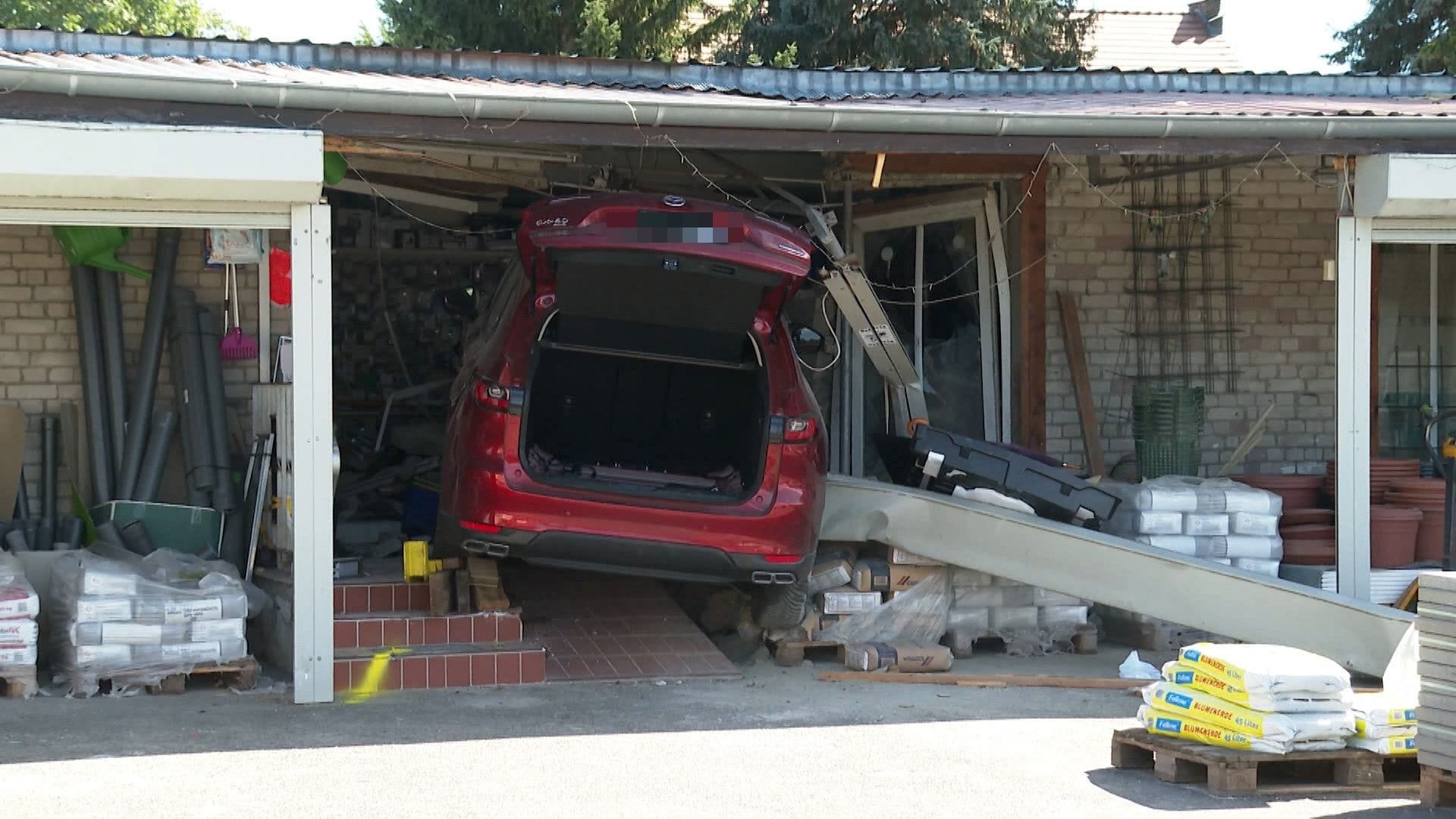 Verunfalltes Auto im Eingangsbereich des kleinen Baumarkts: