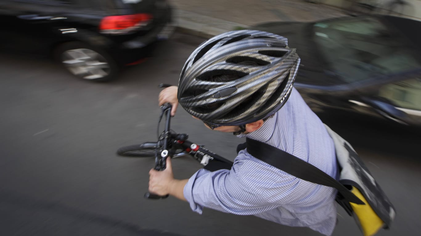 Eine junger Mann fährt mit Fahrradhelm