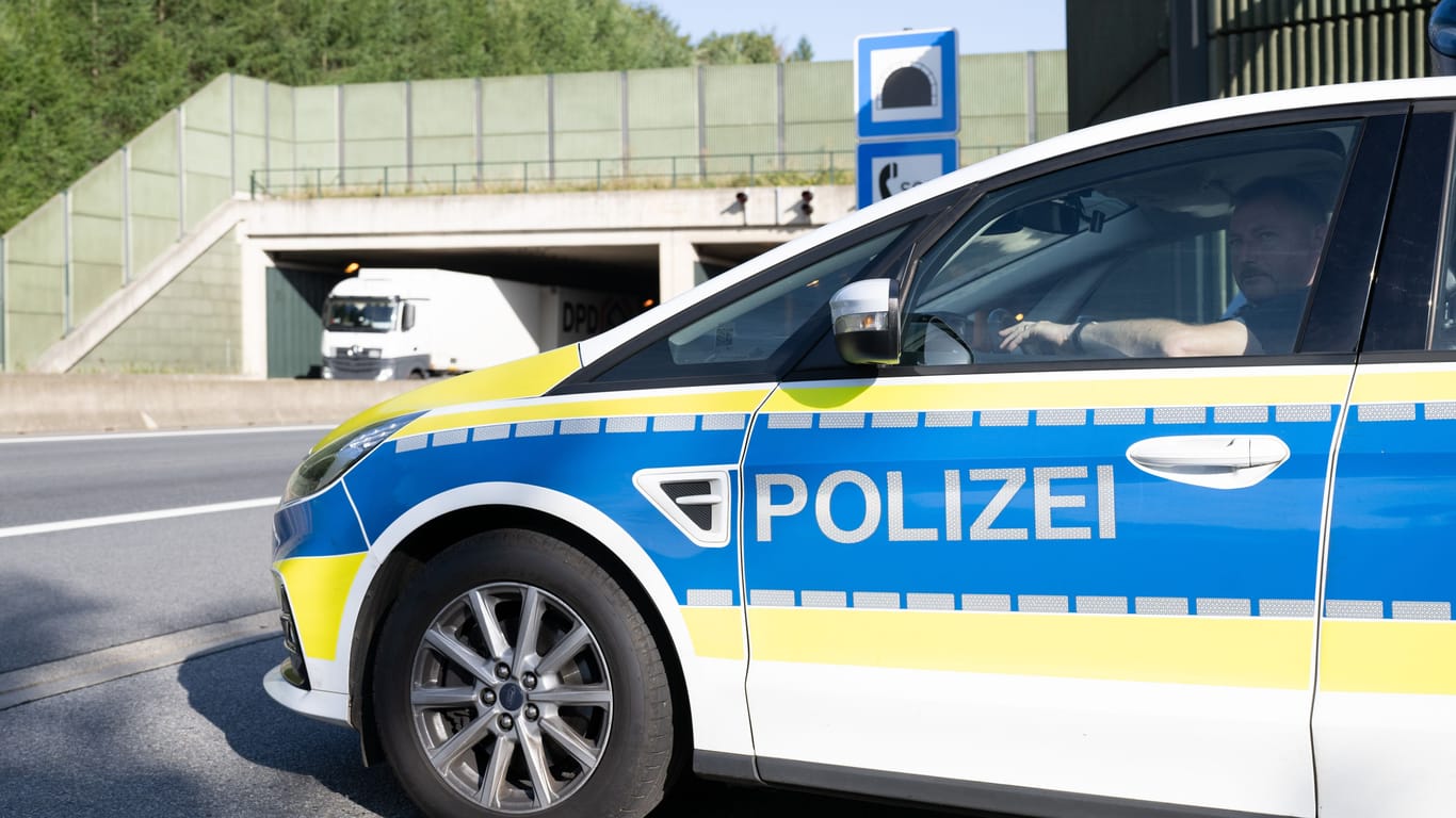 Ein Bundespolizist sitzt an einer Ausfahrt der A17 nahe der deutsch-tschechischen Grenze in einem Polizeiauto: Sein prüfender Blick liegt auf den vorbeifahrenden Fahrzeugen.