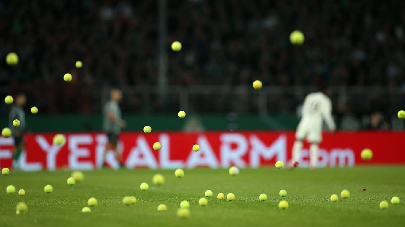 Tennisbälle fliegen beim Bayern-Spiel in Münster aufs Feld.