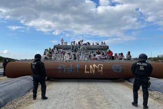 Mehr als hundert Aktivisten besetzen Pipeline-Rohre auf dem Mukran Hafengelände. Das große Polizeiaufgebot wurde regelrecht überrannt.