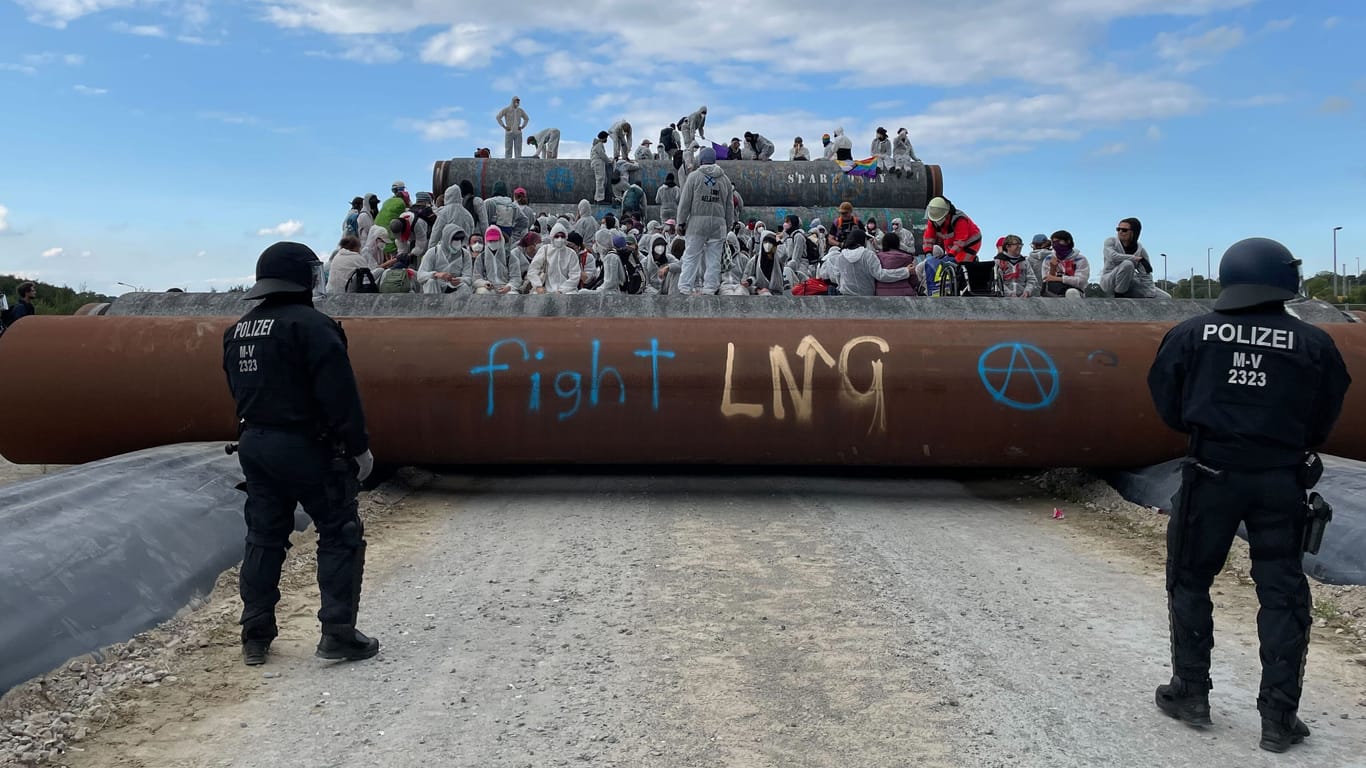 Mehr als hundert Aktivisten besetzen Pipeline-Rohre auf dem Mukran Hafengelände. Das große Polizeiaufgebot wurde regelrecht überrannt.
