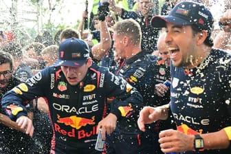 Red-Bull-Pilot Max Verstappen (li.) während der Feierlichkeiten nach dem Sieg in Monza. Teamkollege Checo Perez (r.) hat Spaß.