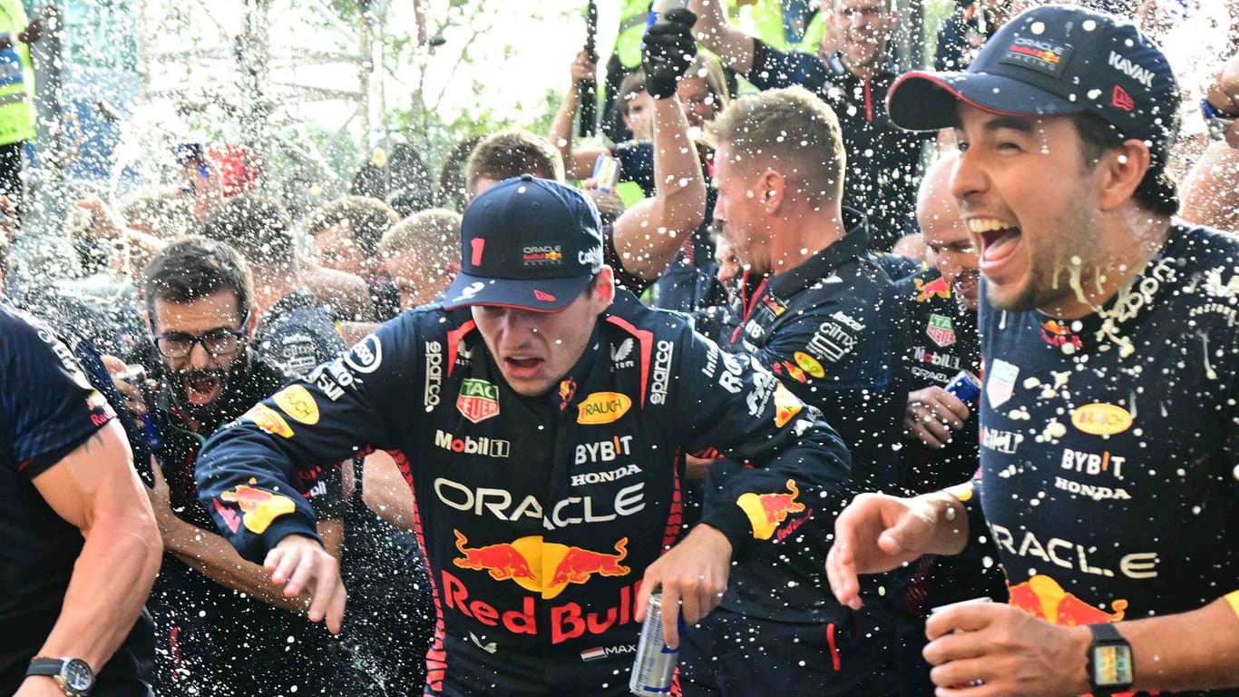Red-Bull-Pilot Max Verstappen (li.) während der Feierlichkeiten nach dem Sieg in Monza. Teamkollege Checo Perez (r.) hat Spaß.