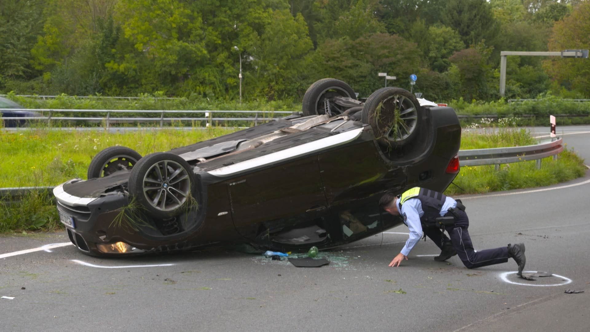 Ein Polizist untersucht das Unfallauto: Nach dem Überschlag landete das Auto auf dem Dach.