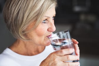 Eine Frau trinkt ein Glas Wasser