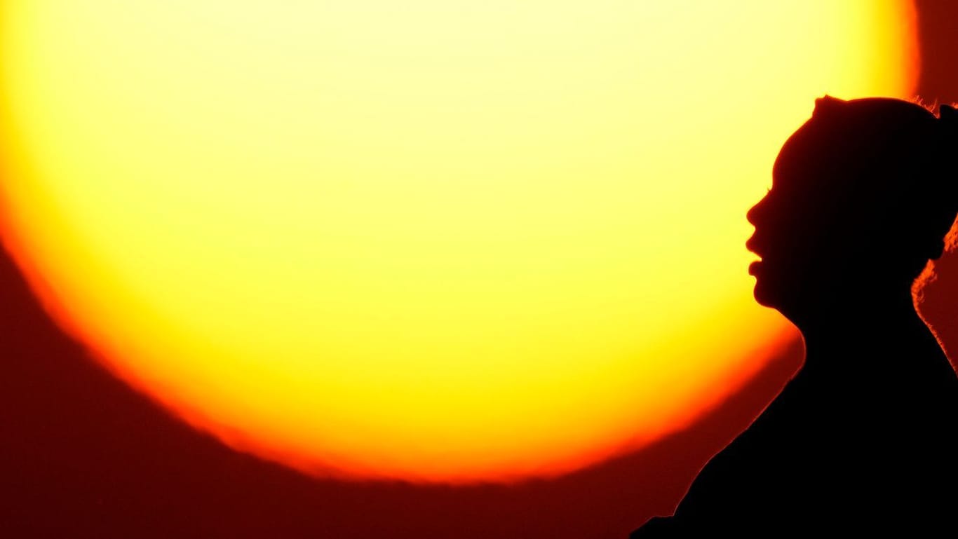 Eine Frauensilhouette vor der Sonne (Symbolbild): Die Ausbeutung des Planeten sorgt für immer größere Risiken.