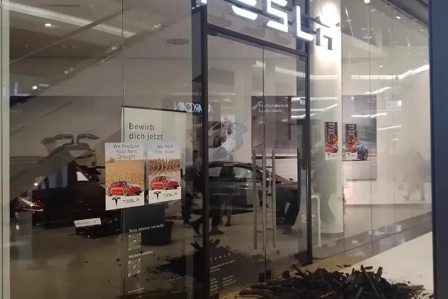 Klimaaktivisten der Gruppe "Sand im Getriebe" protestieren vor einem Tesla-Store in Berlin gegen die Erweiterung des Tesla-Werks in Grünheide.