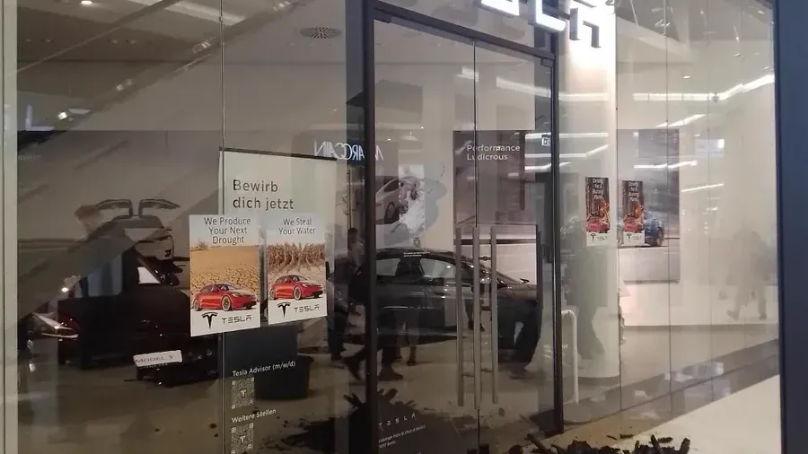 Klimaaktivisten der Gruppe "Sand im Getriebe" protestieren vor einem Tesla-Store in Berlin gegen die Erweiterung des Tesla-Werks in Grünheide.