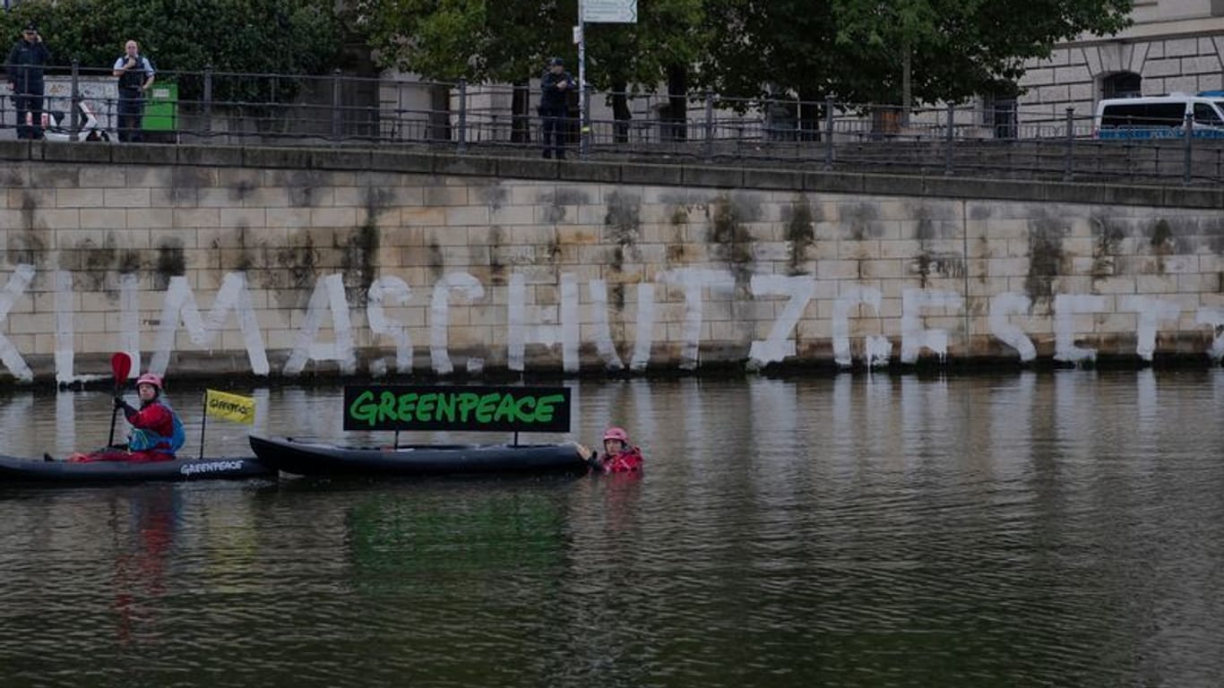Aktivisten von Greenpeace an der Kaimauer unterhalb des Reichstages