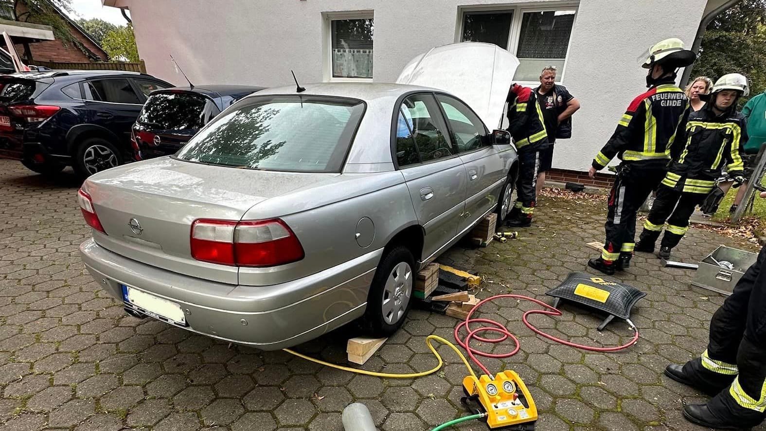 Einsatzkräfte der Feuerwehr an dem Wagen: Es dauerte über eine halbe Stunde, um das Tier herauszuholen. Einsatzkräfte der Feuerwehr an dem Wagen: Es dauerte über eine halbe Stunde, um das Tier herauszuholen.